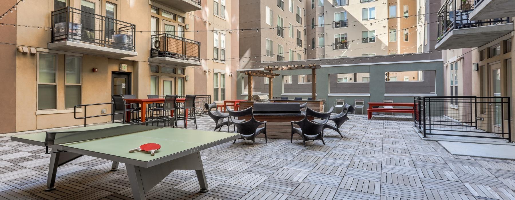 a courtyard with tables and chairs in it with buildings in the back