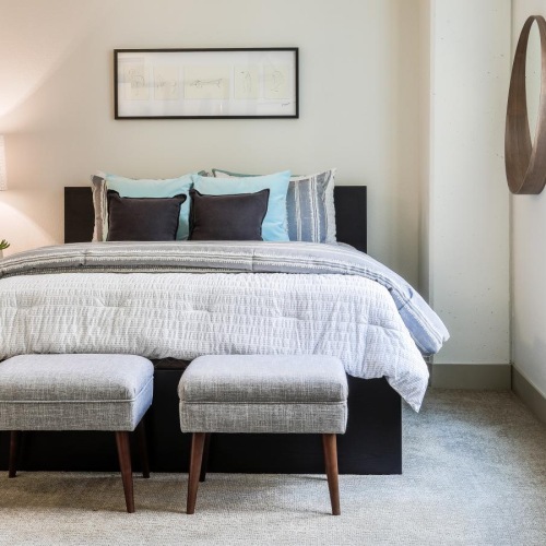 a bed with a chair and a lamp in a room